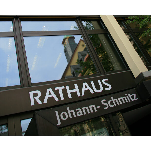 Das Symbolbild zeigt die Schrift RATHAUS über dem Eingang zum Rathaus am Johann-Schmitz-Platz 1 bis 3.
