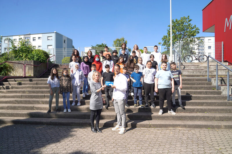 Vor den Schülerinnen und Schülern übergab Francesco Calio (vorne rechts), Geschäftsführer der Pierenkemper GmbH, einen Gutschein symbolisch an Schulleiterin Monika Azizmohammadi.