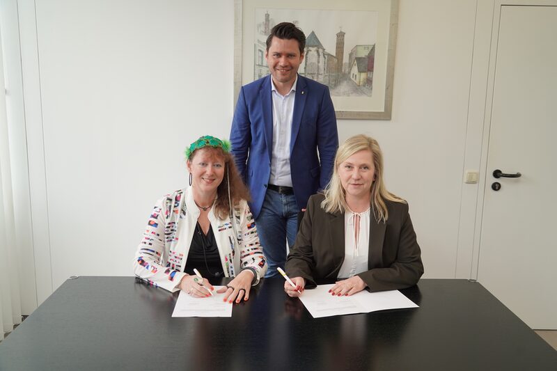 Staatssekretärin Andrea Milz (l.) und Bürgermeisterin Susanne Stupp (r.) unterzeichneten die Vereinbarung im Beisein von dem Landtagsabgeordneten Thomas Okos (M.).