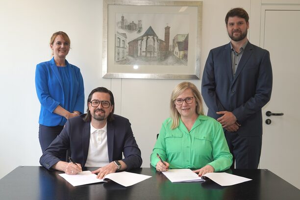 Dr. Carsten Schäfer (vorne links) und Bürgermeisterin Susanne Stupp (vorne rechts) unterschrieben den Mietvertrag im Beisein der Ersten Beigeordneten und Kämmerin Gudrun van Cleef und dem Abteilungsleiter Kaufmännisches Immobilienmanagement David Passon.