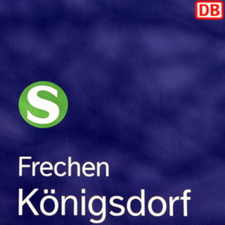 Die Aufnahme zeigt das blaue Bahnhofsschild Frechen Königsdorf.