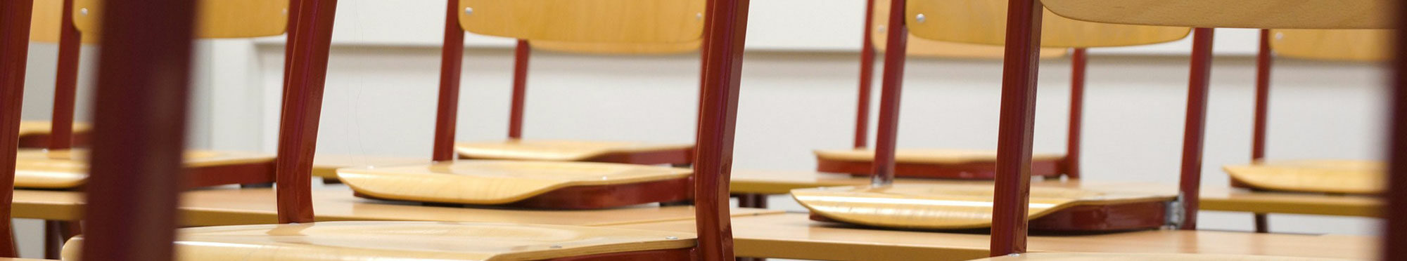Das Bild zeigt einen Ausschnitt aus einem Klassenzimmer. Die Stühle sind hochgestellt.