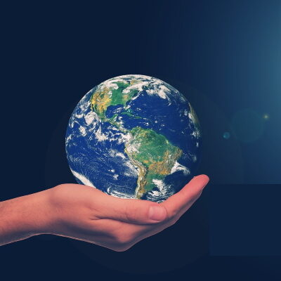 Das Bild zeigt eine Hand, die die Erde hält.