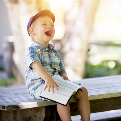Ein lachende Junge mit dem Buch