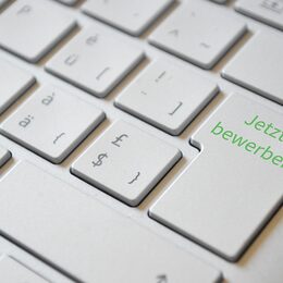 Das Bild zeigt eine Tastatur mit einer Enter-Taste, auf der "Jetzt bewerben" steht