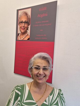 Frau Aryani vor Ausstellungstafel